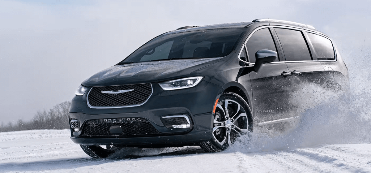 The 2024 Chrysler Pacifica Pinnacle minivan model with AWD traveling through a field of snow in winter