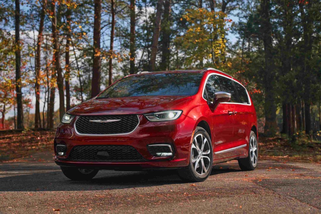 a red 2024 Chrysler Pacifica parked near the forest. 