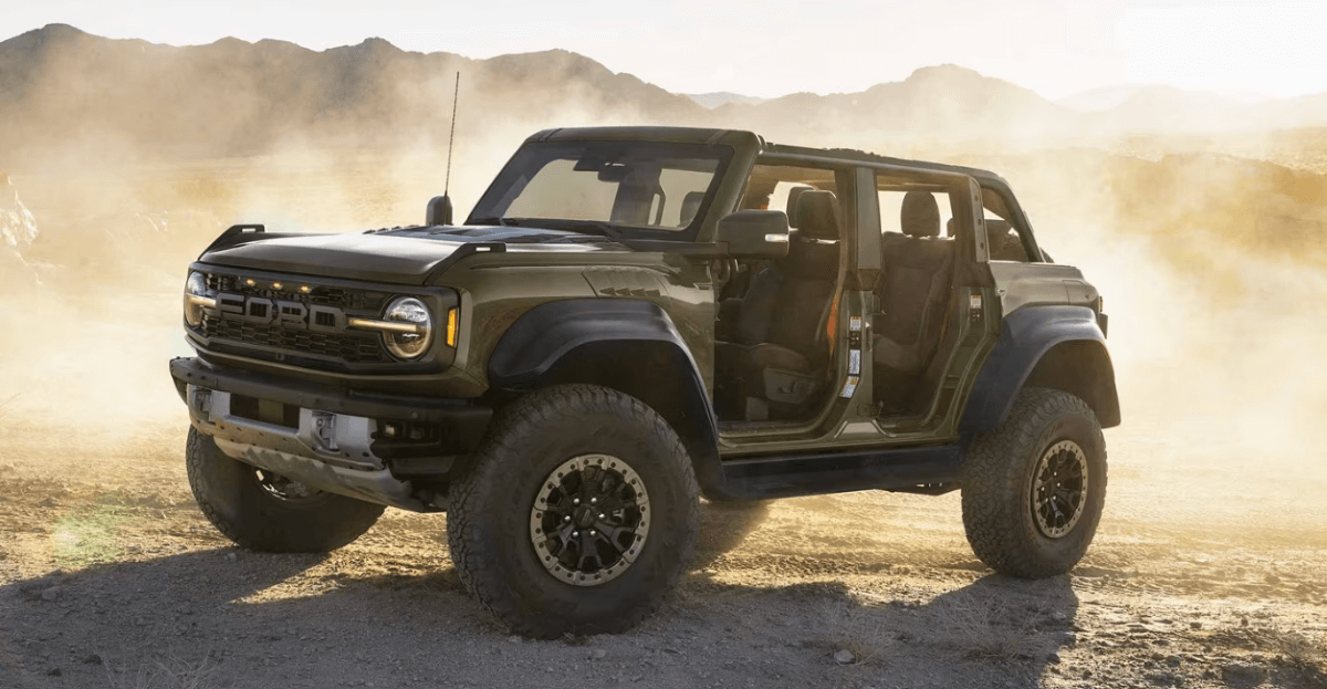 A 2024 Ford Bronco Raptor compact off-road SUV model with removable doors and all-terrain tires in a dust storm