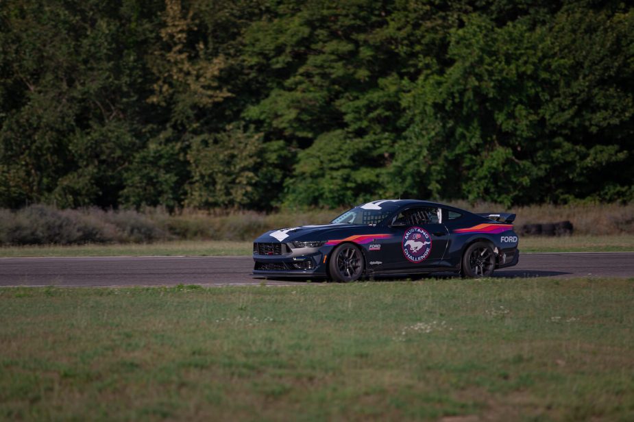 A black 2024 Ford Mustang Dark Horse on the track.