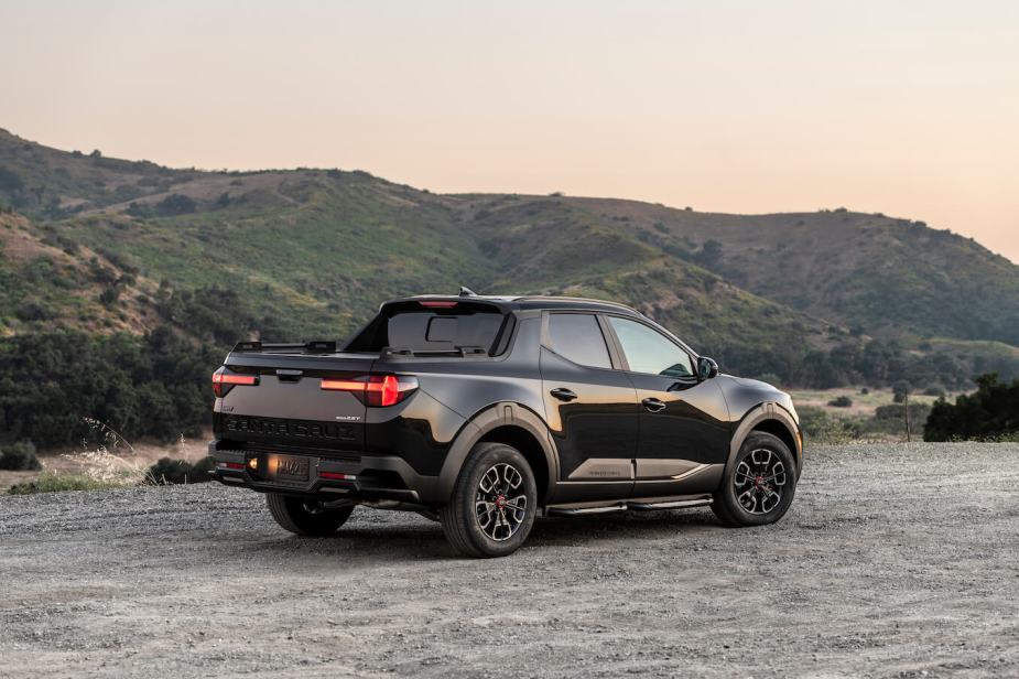 A black Hyundai Santa Cruz parked in front of some low mountains. It's behind Tacoma sales but just as good.