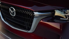 The front of a red 2024 Mazda CX-90 midsize three-row SUV.