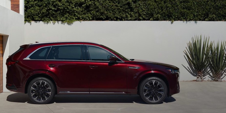 A red 2024 Mazda CX-90 midsize three-row SUV is parked. 