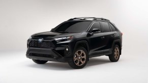 A black 2024 Toyota RAV4 Hybrid Woodland Edition against a white backdrop.