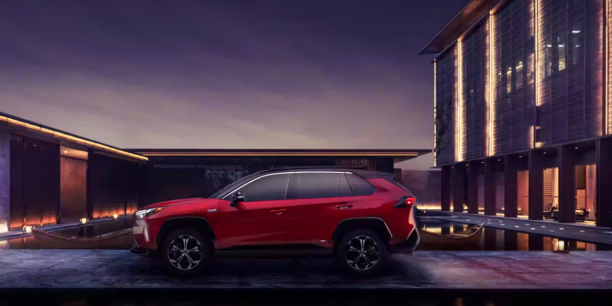 A red 2024 Toyota RAV4 Prime small plug-in hybrid SUV is parked.