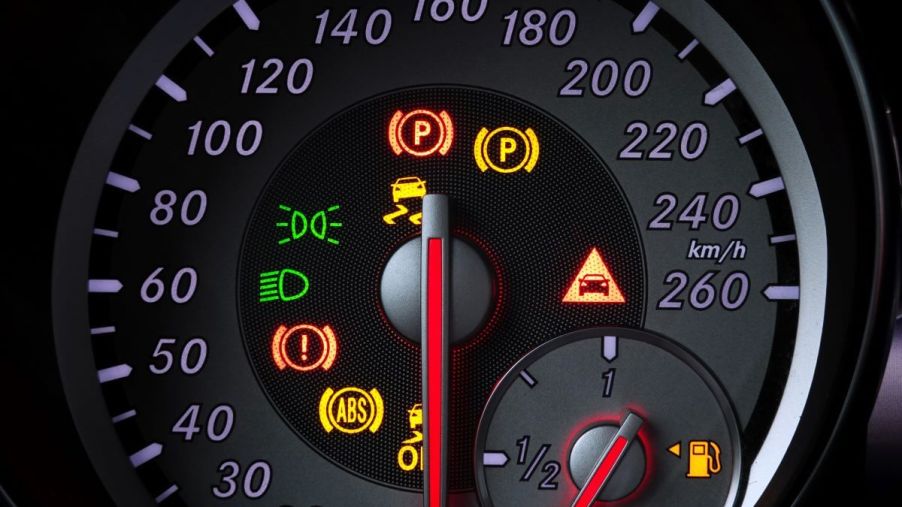 A car's speed display with illuminated warning lights, including the ABS (Anti-lock Brake System) light