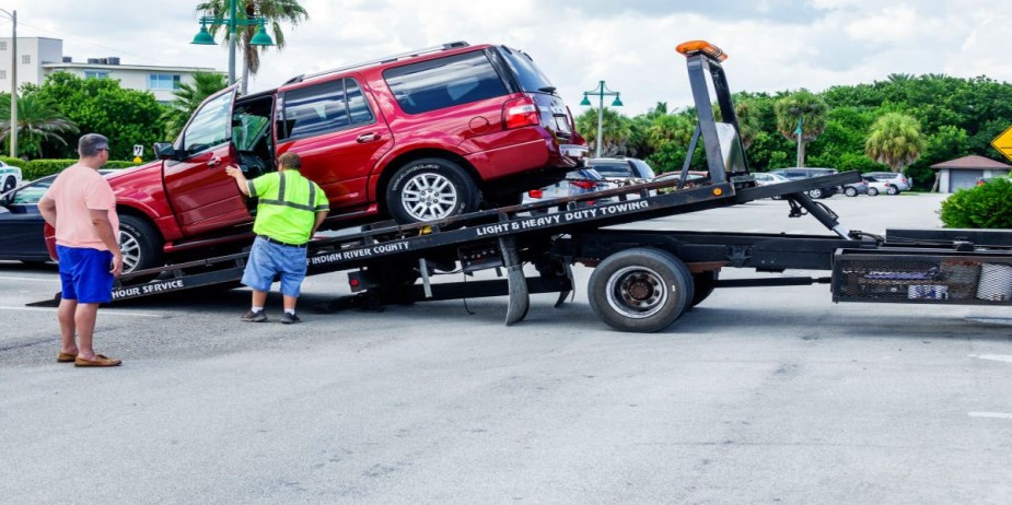 An SUV is being towed. 