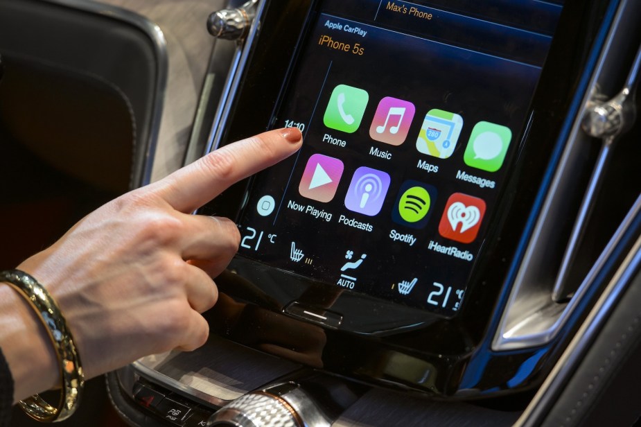 A person shows how to turn CarPlay on and off while at a car show.