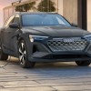 A gray Audi e-tron luxury electric midsize SUV is charging.