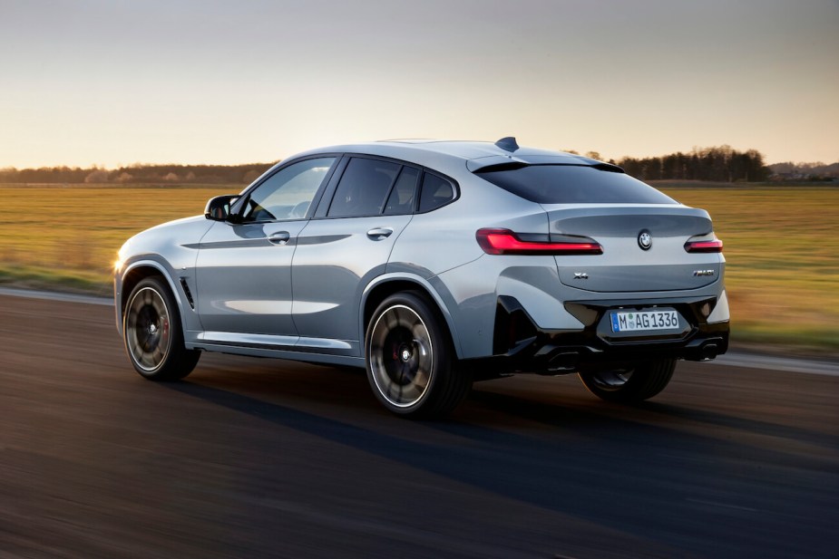 The BMW X4, the most satisfying compact luxury SUV, in gray driving down an empty road.