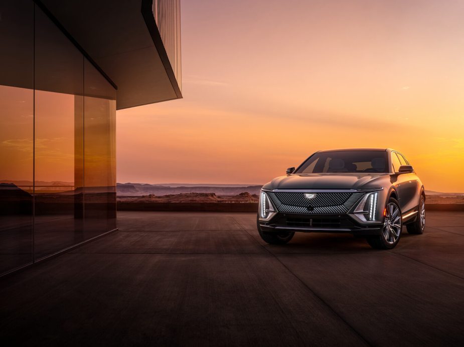 A dark Cadillac Lyriq parked in front of a window at twilight. Cadillac Lyriq sales are finally picking up.