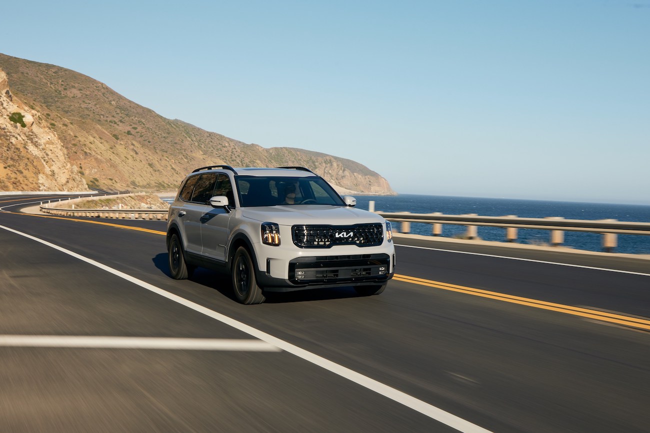 The 2024 Kia Telluride in gray driving along a cliff road. The cheapest Kia Telluride is hard to find because it's popular.