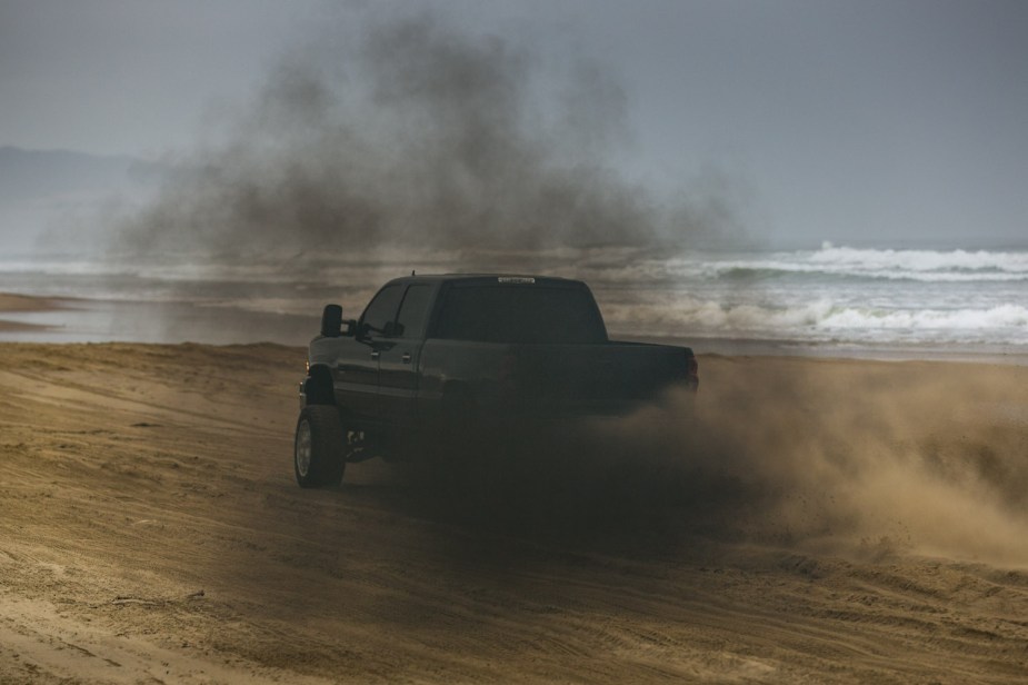 Deleted diesel pickup truck rolling coal on Pismo Beach in California.