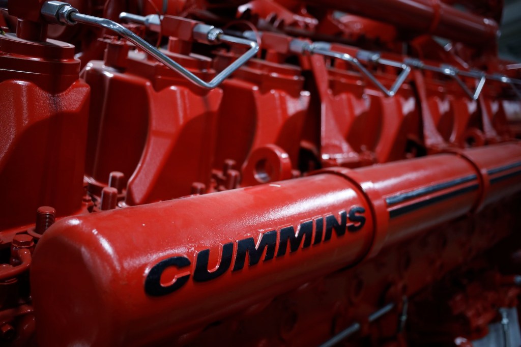 Closeup of the Cummins logo on a red diesel engine.