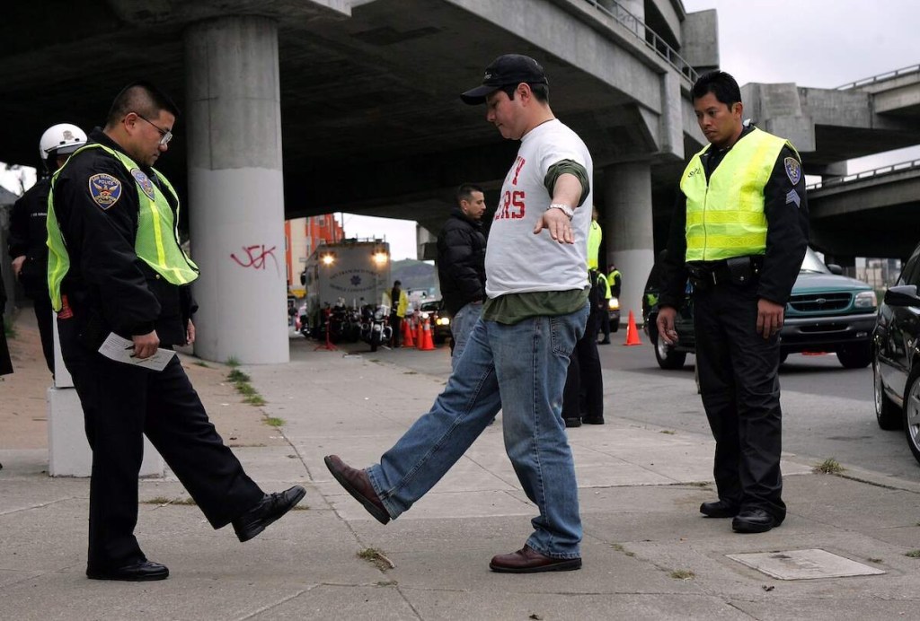 A driver takes a field sobriety test at a DUI checkpoint