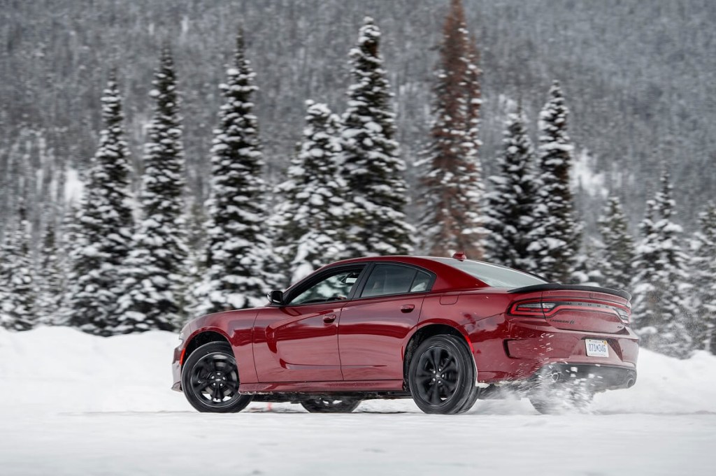A red Dodge Charger GT kicks up snow with AWD.