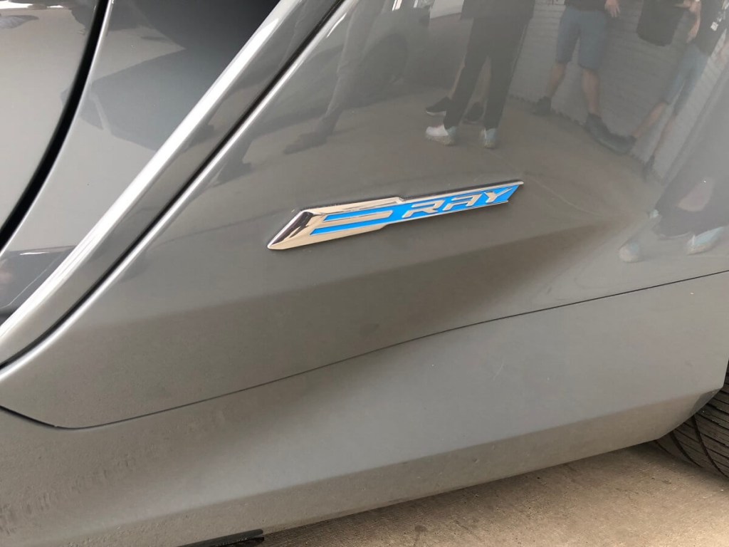 A gray 2024 Chevrolet Corvette E-Ray flashes its badge. 