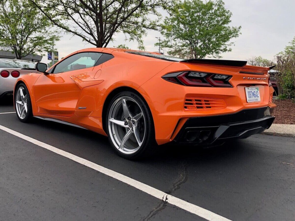 The fastest stock Chevy car, the 2024 Corvette E-Ray, displays its bright-orange paint. 