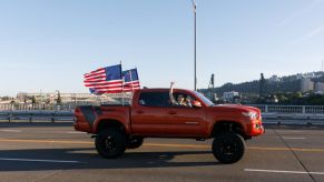 American flags flying on a pickup truck