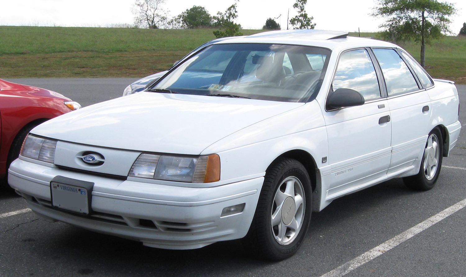 White Ford Taurus sedan SHO edition by SVT in a parking lot.