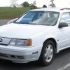 White Ford Taurus sedan SHO edition by SVT in a parking lot.