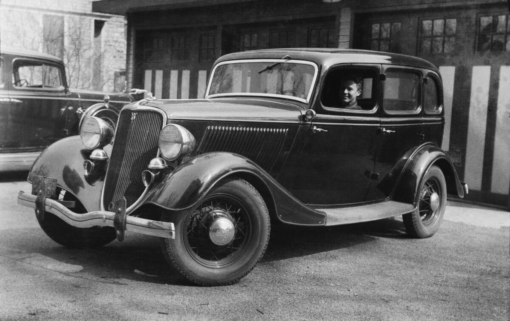 A black Ford Model 40 B Fordor Deluxe like the gangster car used by Bonnie and Clyde shows off its gangster car credentials akin to a Cadillac or Lincoln Continental of the era. 