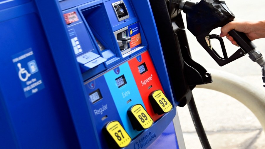 A person removes the nozel from a pump at a gas station on July 29, 2022 in Arlington, Virginia.