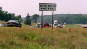 "Slower cars move right" sign posted in grass