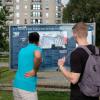 Tourists in Berlin, Germany, reading an information board about Adolf Hitler's hidden bunker and gravesite