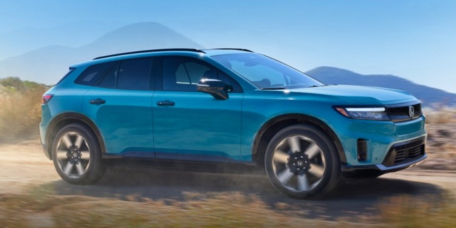 A blue Honda Prologue EV electric SUV is driving off-road. 