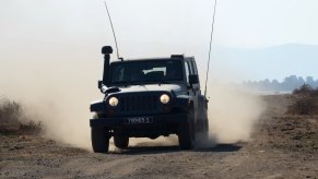 The Israeli Defense Force's military Jeep based on the Wrangler drives through the desert, a cloud of dust in the background.