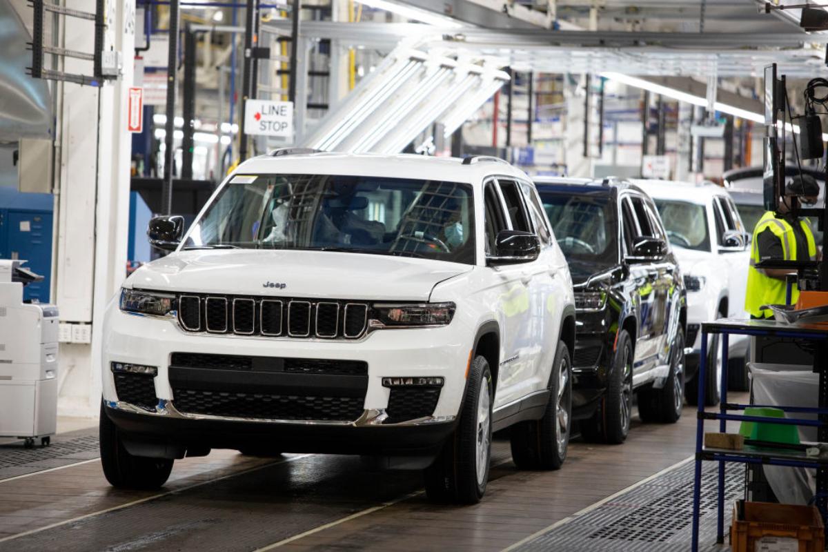 A line of Jeep Grand Cherokee L SUVs at an assembly plant.