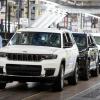 A line of Jeep Grand Cherokee L SUVs at an assembly plant.