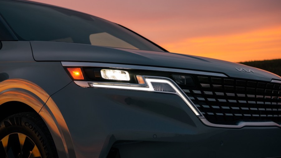 A close-up shot of the Kia Carnival at dusk. It's rated as the most satisfying minivan in 2023.
