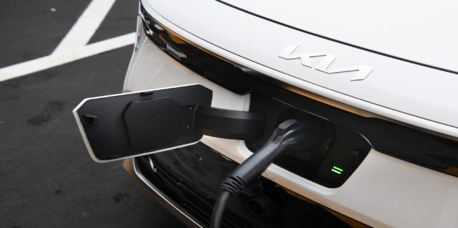 A white 2024 Kia Niro EV subcompact electric SUV is charging.