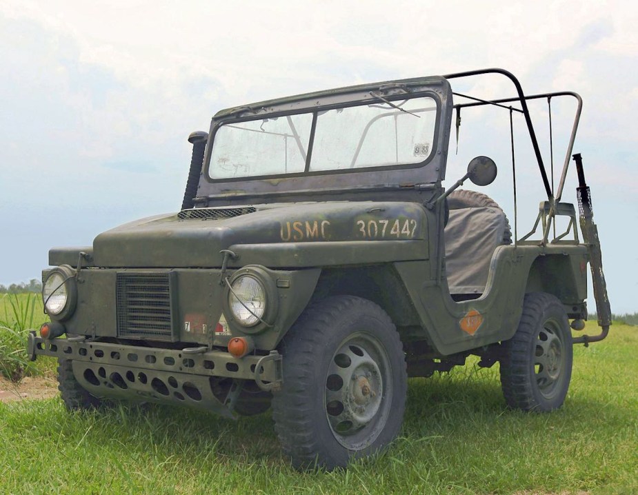 Olive green Mighty Mite mini Jeep parked in a field.