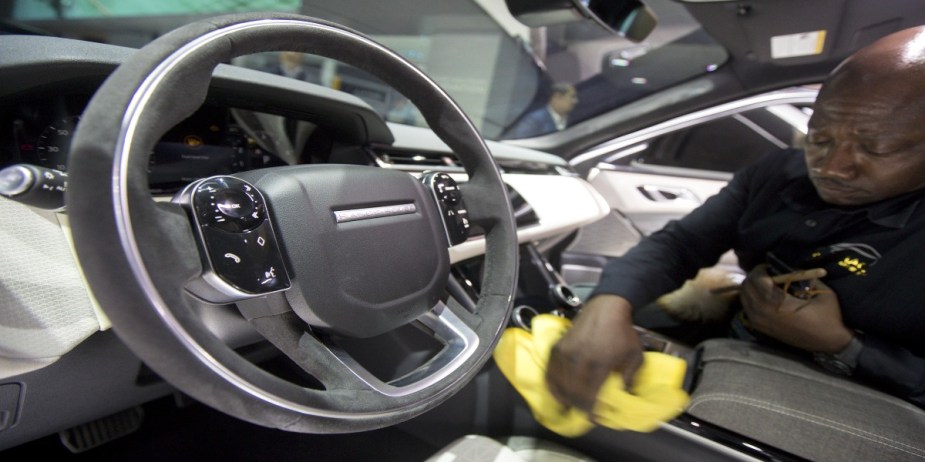 A worker cleans the interior of a Jaguar Land Rover Automotive Plc Range Rover Velar HSE sport utility vehicle (SUV) during the 2017 New York International Auto Show (NYIAS) in New York, U.S.