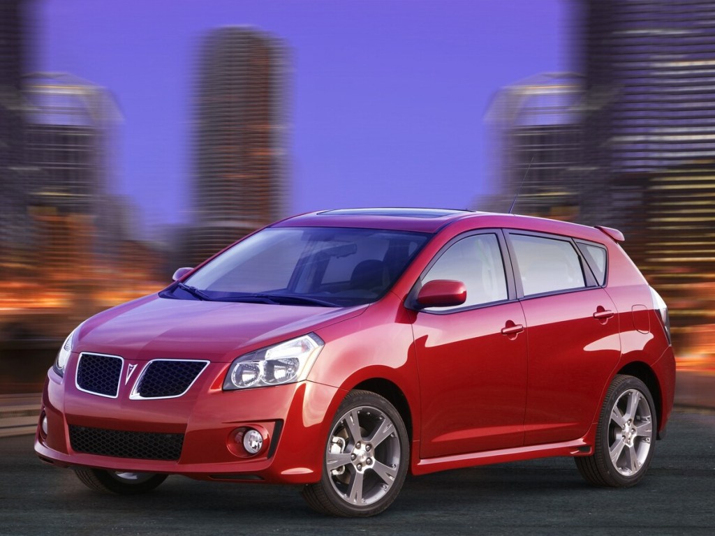 Red 2005 Pontiac Vibe with city background