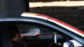 A driver pauses with a cigar while behind the wheel on April 30, 2016 in New York, New York. Do smoking laws prohibit this?