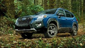 A blue Subaru Forester Wilderness small SUV is parked off-road.