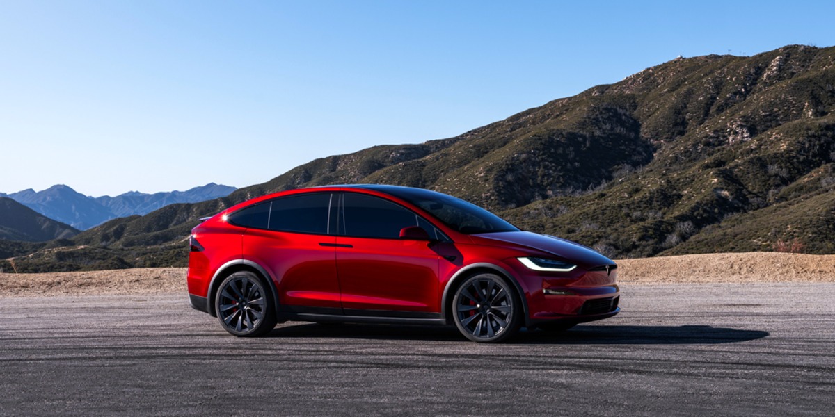 A red 2023 Tesla Model X is parked.