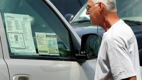 Man looking at vehicle window sticker