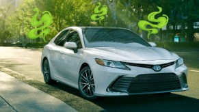 A white Toyota Camry midsize sedan is parked.