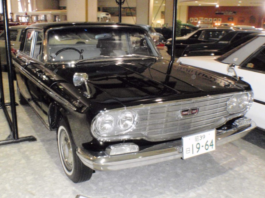 An original Toyota Crown luxury sedan with a V8 engine is parked in a museum.
