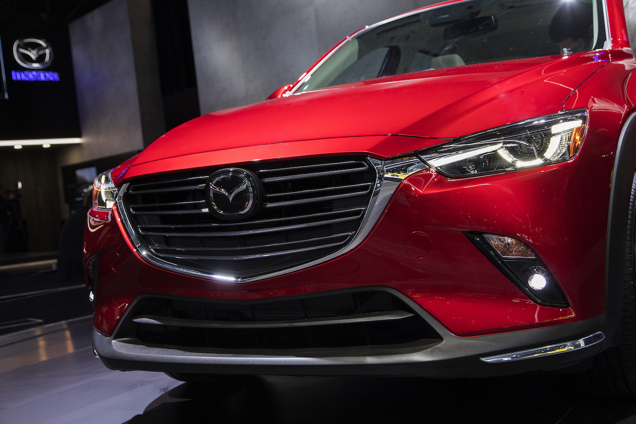 A red Mazda CX-3 grill up close at an auto show. Used Mazda CX-3 reliability is an important factor to consider.