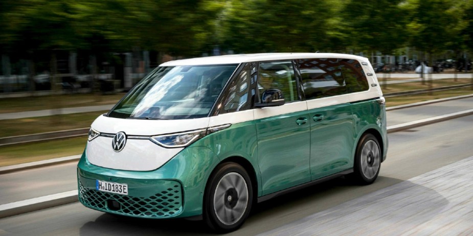 A green Volkswagen ID. Buzz electric microbus is driving on the road. 