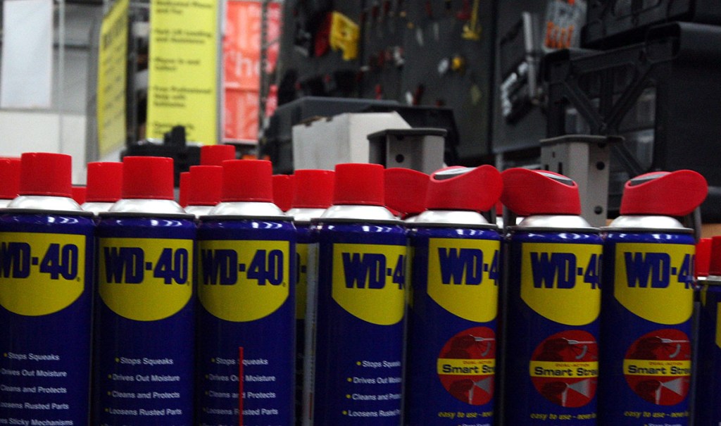 A hardware store shelf containing WD40 cans with aligned labels