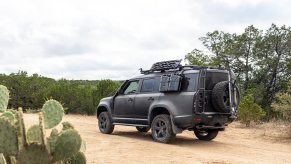 A matte black 2024 Land Rover Defender 130 sits on a trail at TReK in Texas.