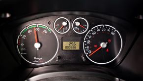 The range, temperature, fuel, and speed gauges on an instrument cluster in a Ford Transit Connect van