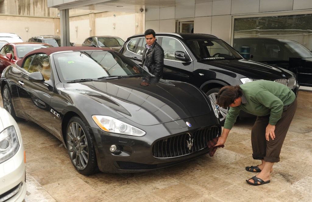 A new car customer inspects an Aston Martin